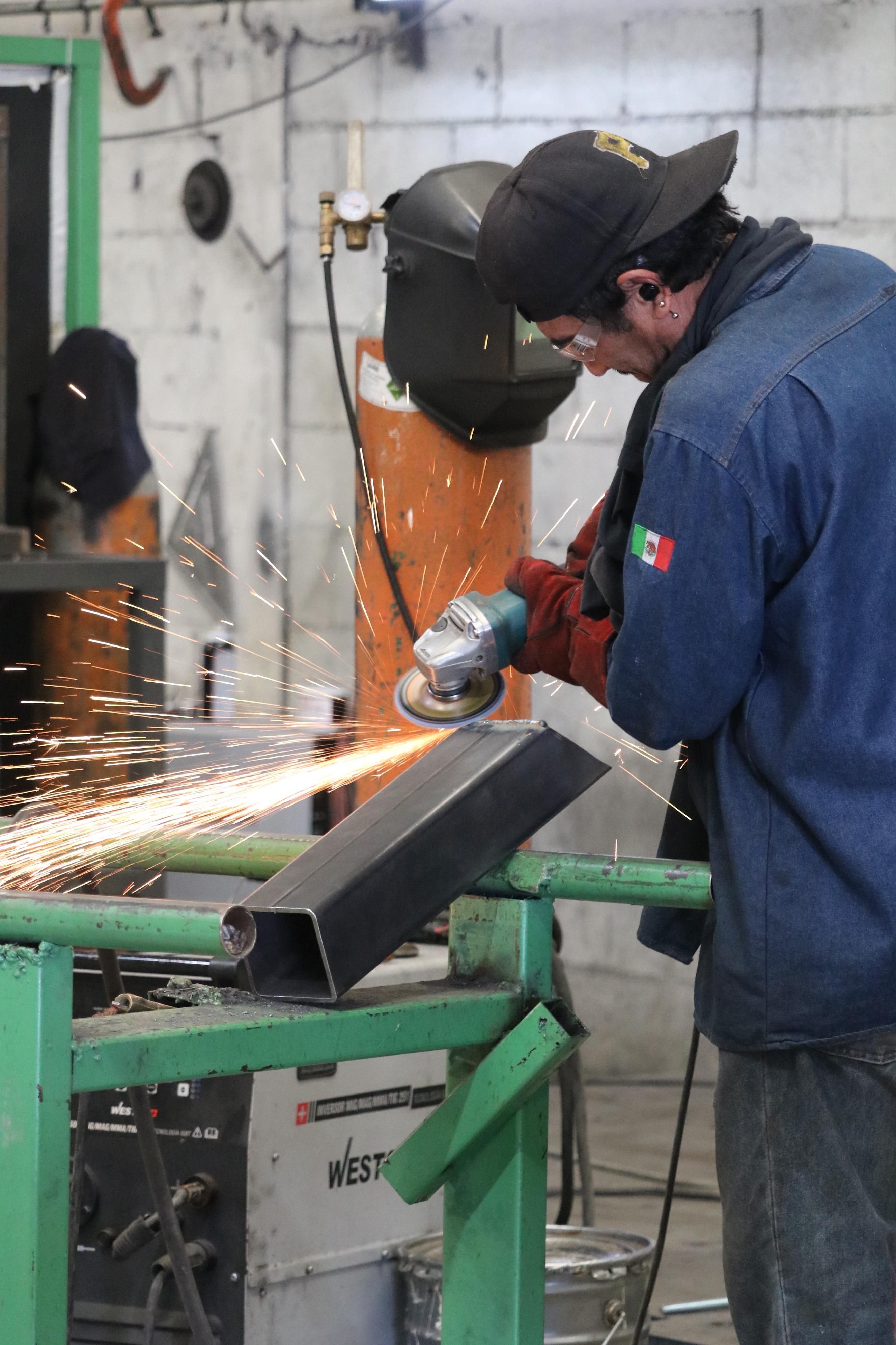 Argon welder grinding a steel tube